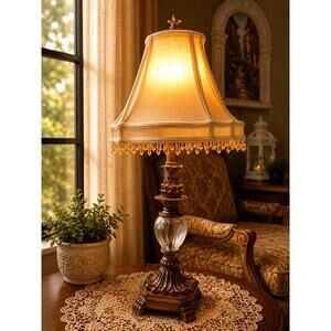 vintage-style table lamp featuring a brown, carved base and clear glass globe